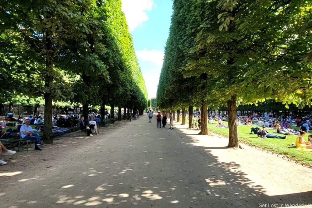 Is Paris overrated? The summer heat can be. Pictured is the crowded  gardens of people trying to relax in the shade