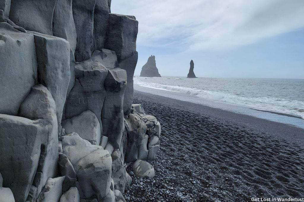 Black Sand Beach featuring basalt columns and black sand as waves come up.