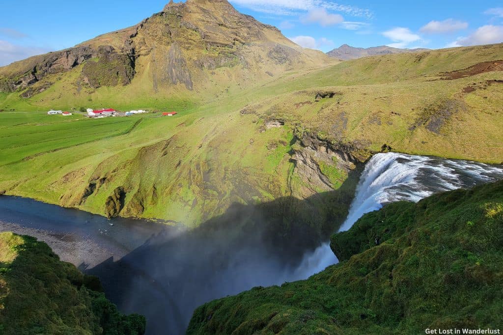 View from the top of Skogafoss over the stunning green landscape of Iceland. 