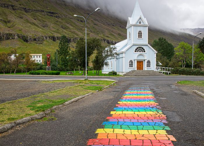 Rainbow road leading to a church in Seyðisfjörður.
