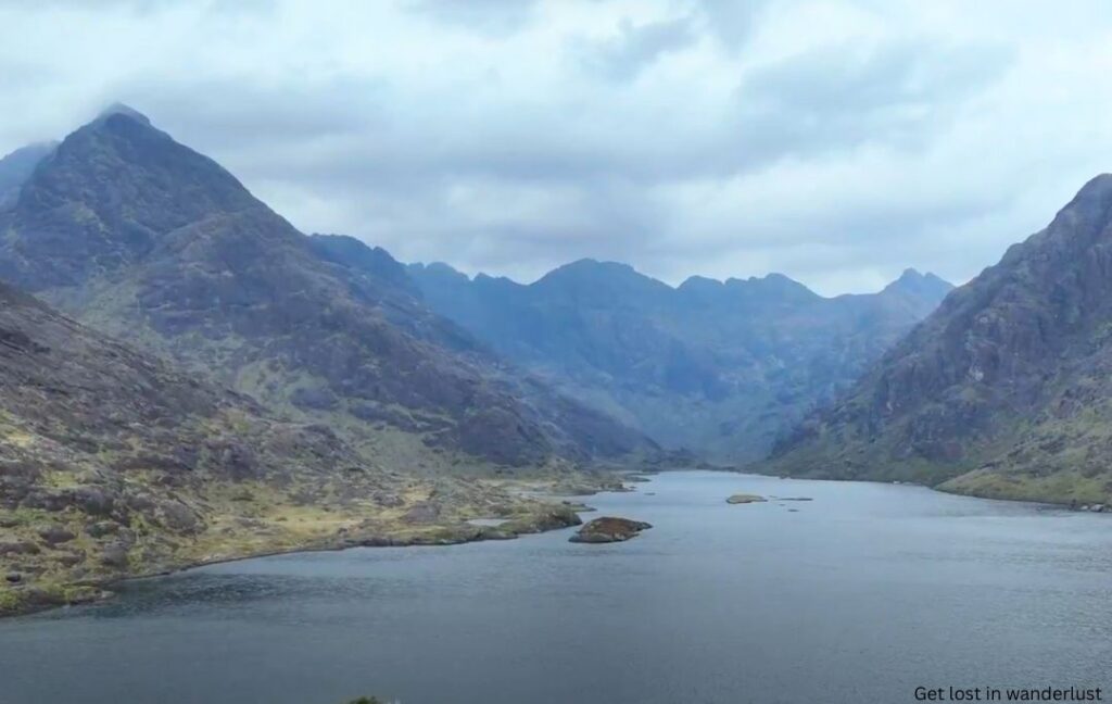 The dark waters of Loch Coruisk with the fog going over the jagged Cuillin Mountains in the distance.