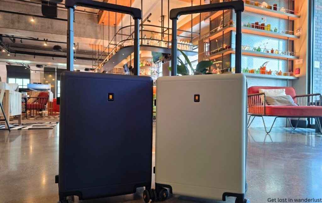 Two of the Level8 luggage suitcases in a modern hotel lobby. The photo shows the sleek, minimalist design of the Level8 luggage.