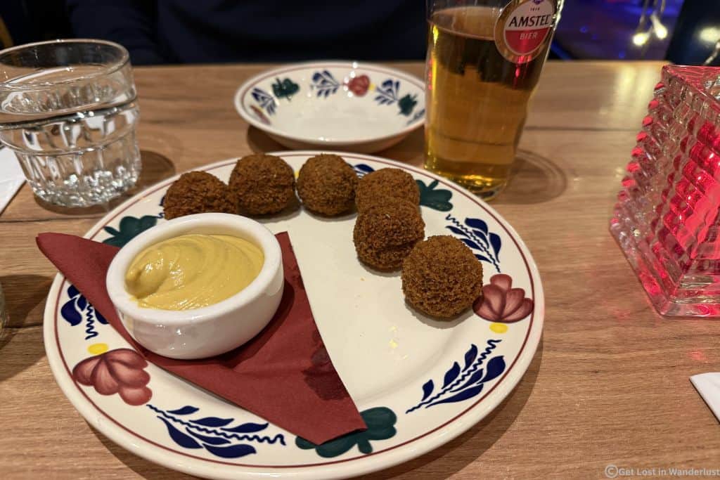 Bitterballen with mustard on a table at a restaurant in Amsterdam.