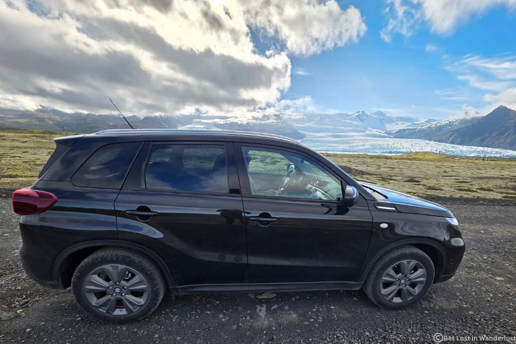 Driving a Suzuki Vitara rental car along Iceland's Ring Road with views of Vatnajökull Glacier in Skaftafell National Park.