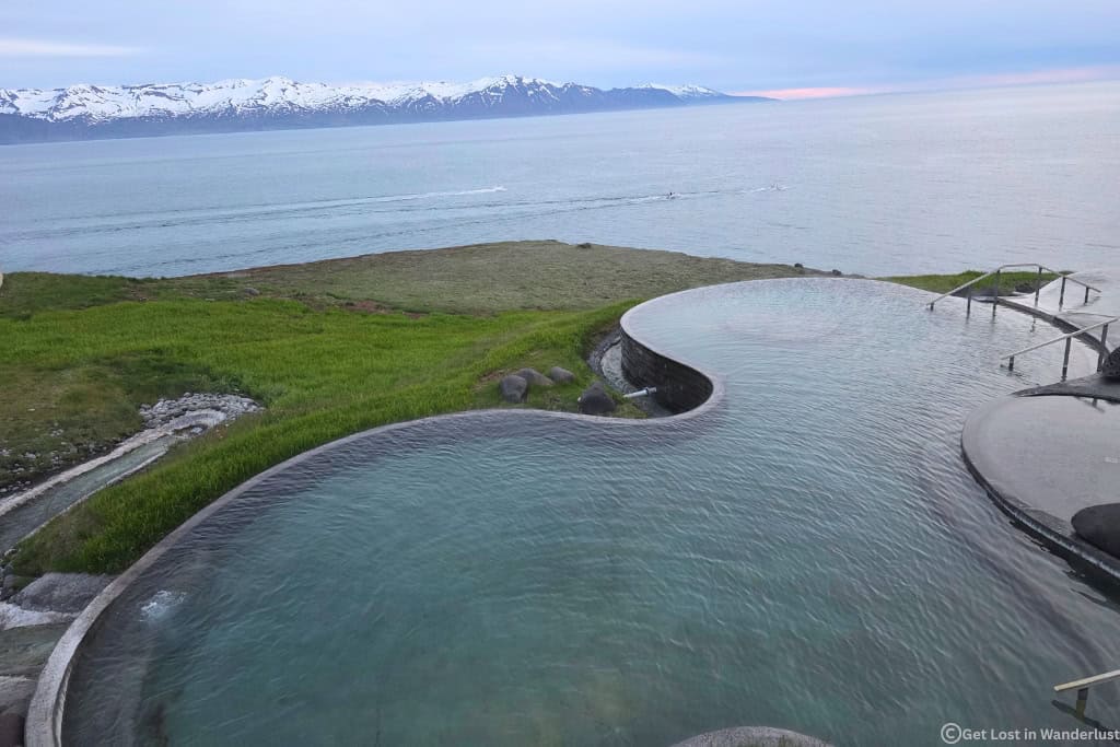 GeoSea lagoon overlooking the bay, with the midnight sun in the distance.
