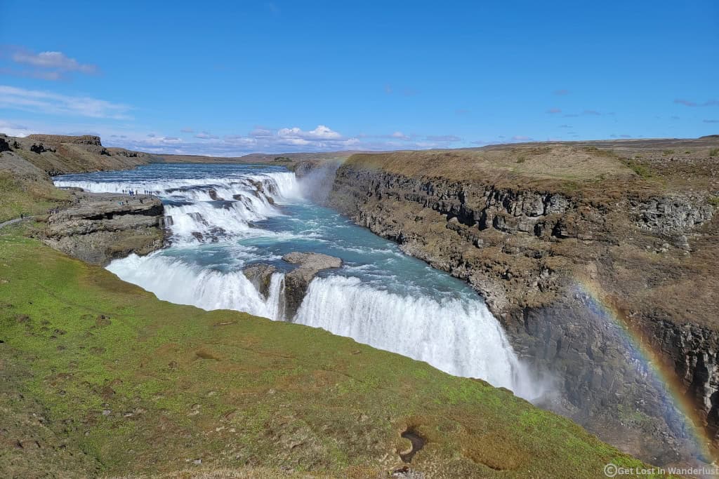 Gullfoss Waterfall in Iceland with cascading glacial water and a rainbow, a must-see stop on the Golden Circle route.
