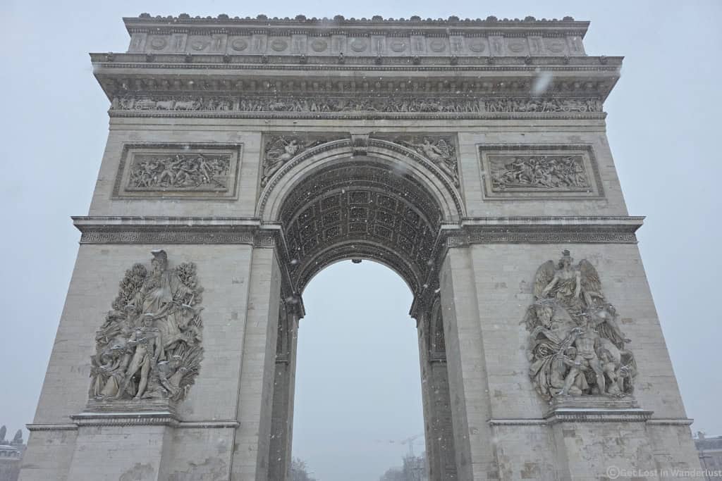Arc de Triomphe in winter with snow falling