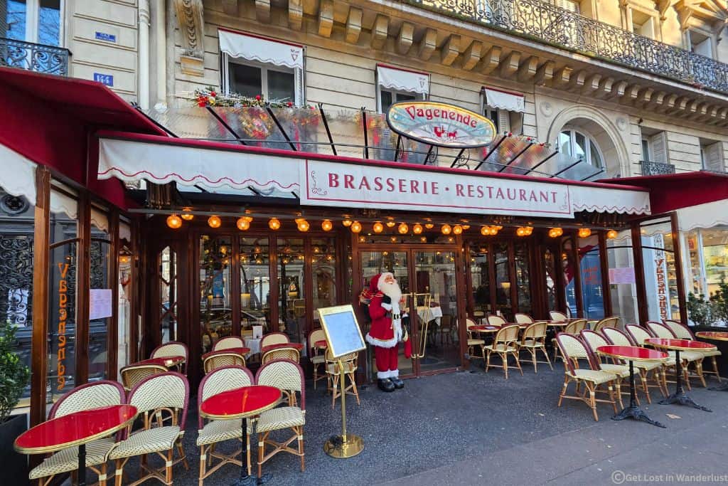Festive Paris brasserie in Saint-Germain decorated for Christmas with a Santa display