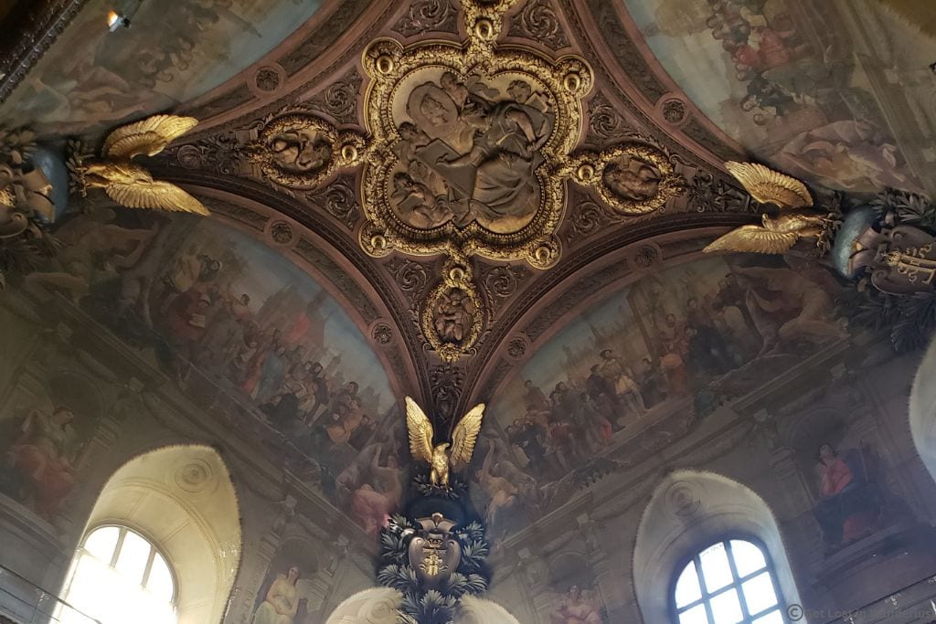 Ornate painted and gilded ceiling inside the Louvre Museum in Paris.
