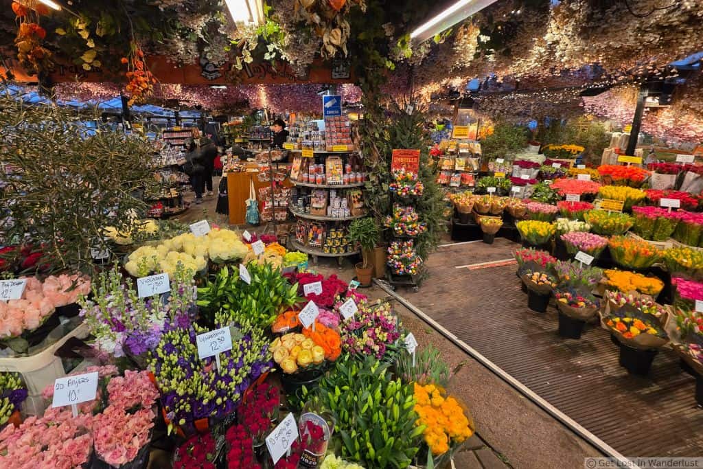 Colorful flower stalls at Amsterdam’s Bloemenmarkt, with bouquets of tulips and other flowers on display.