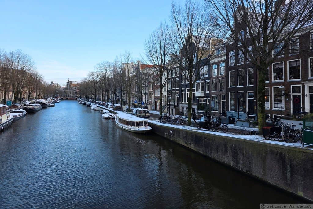 Canal in Amsterdam’s South Canal Belt lined with historic canal houses, bicycles, and boats on a quiet winter day. This is one of the best and safest neighborhoods in Amsterdam.