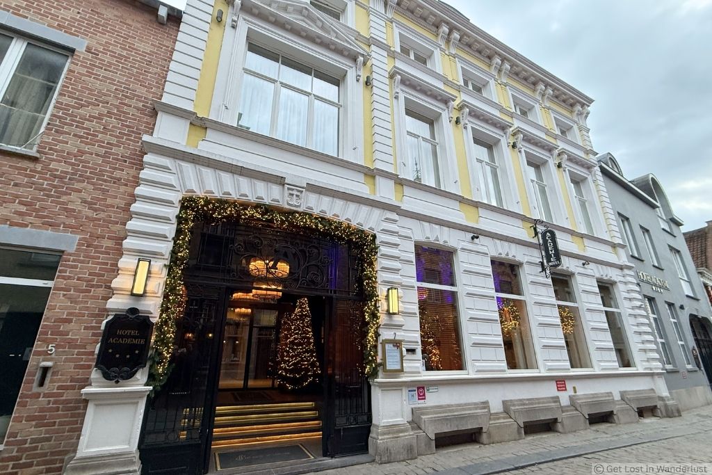 Dukes’ Academie Hotel in Bruges decorated for Christmas, with festive lights and a Christmas tree visible at the entrance.