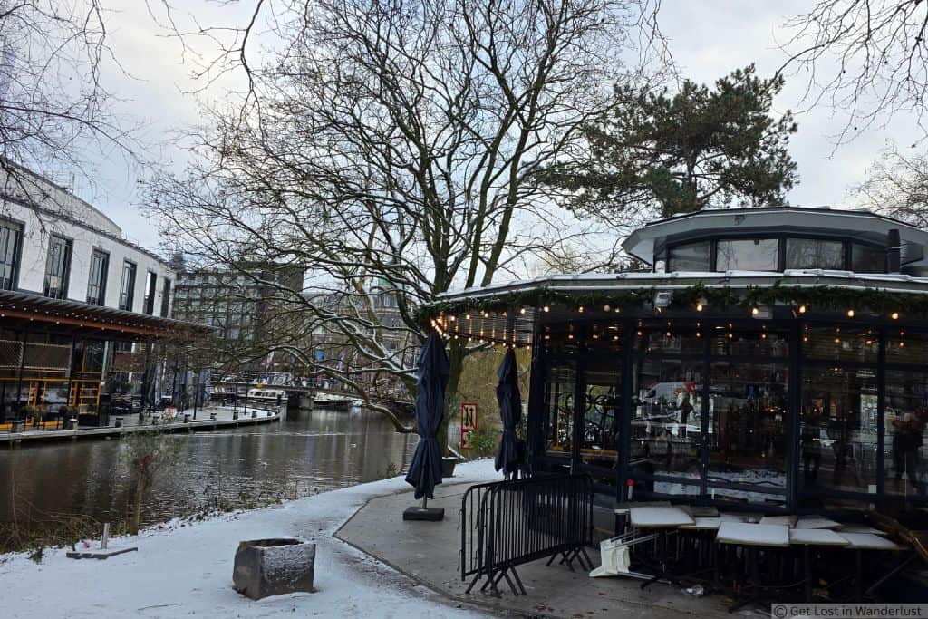 Canal and restaurant in Amsterdam’s Museum Quarter, with outdoor seating and trees along the water.